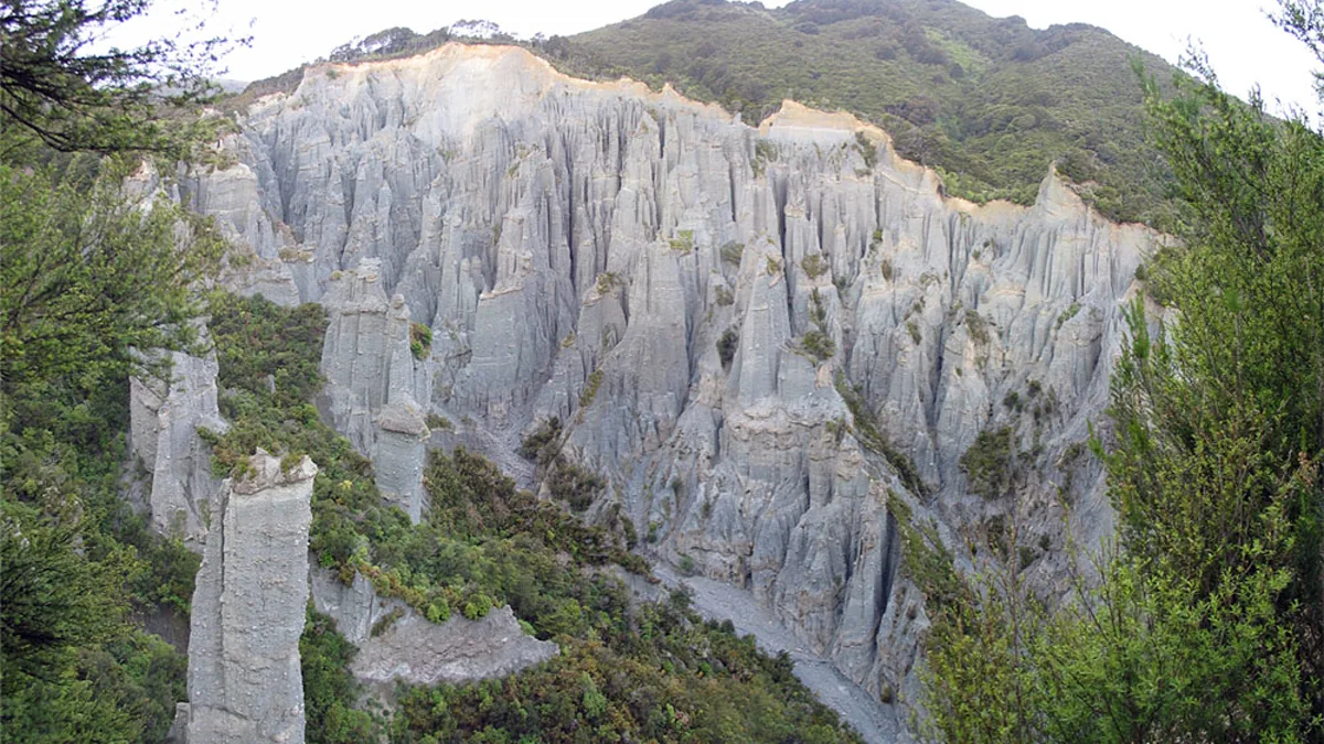 Narrow gravel gorge surrounded by tall eroded silt and gravel pinnacles